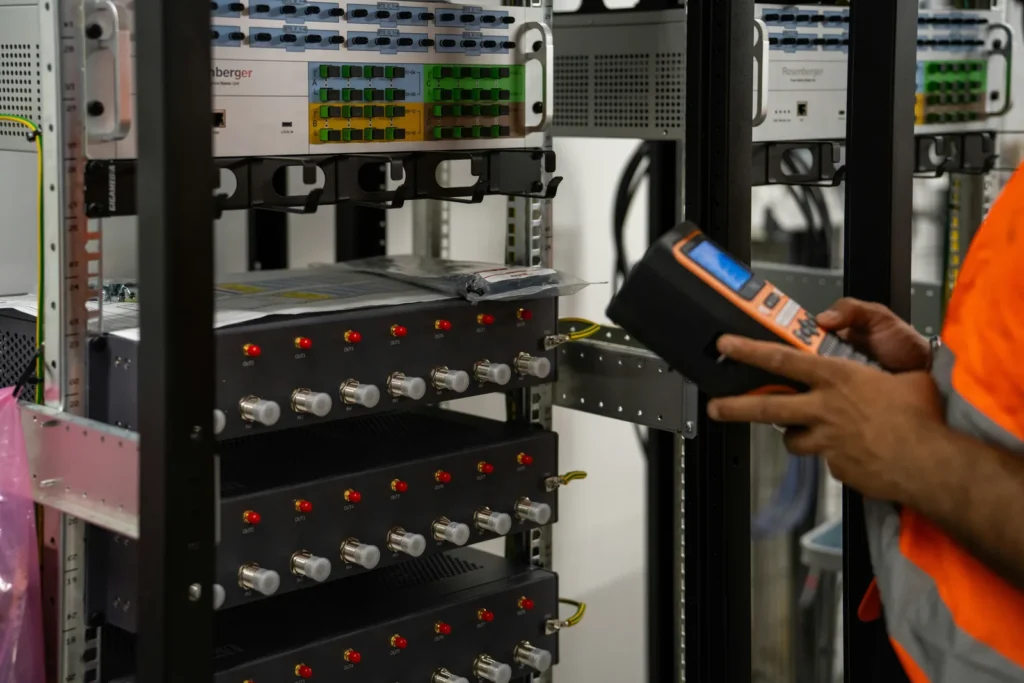 Technician using an instrument beside equipment