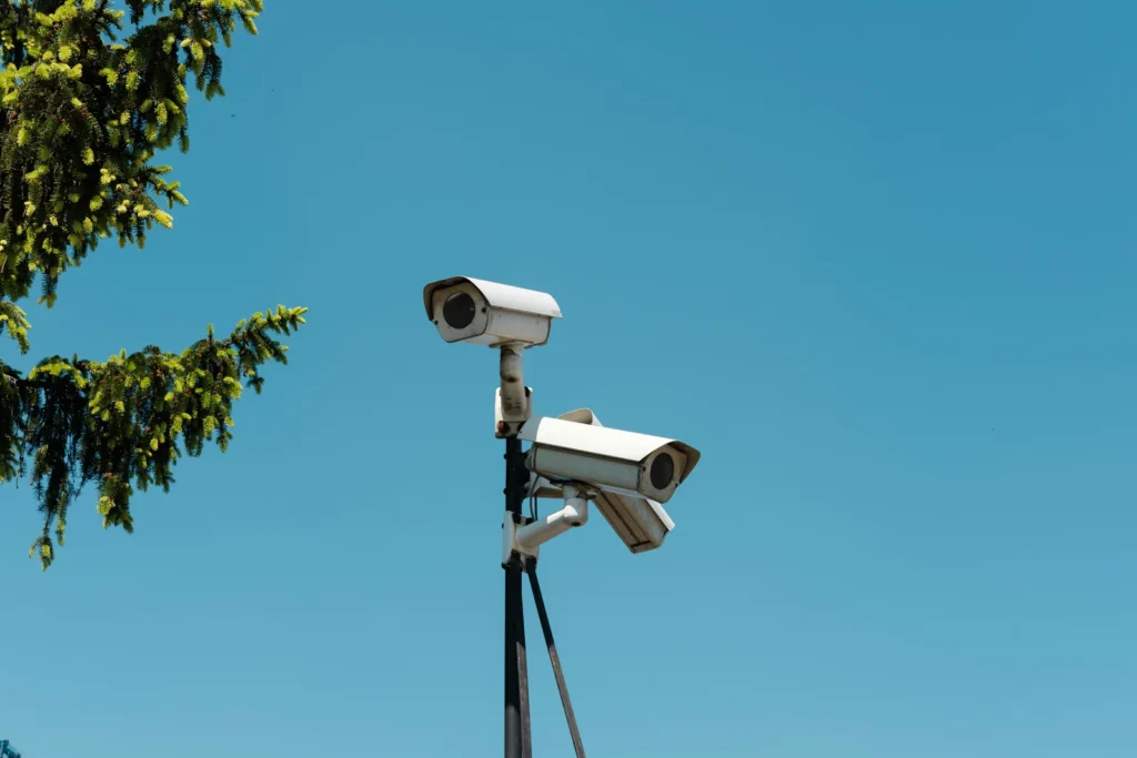 Two security cameras against blue sky